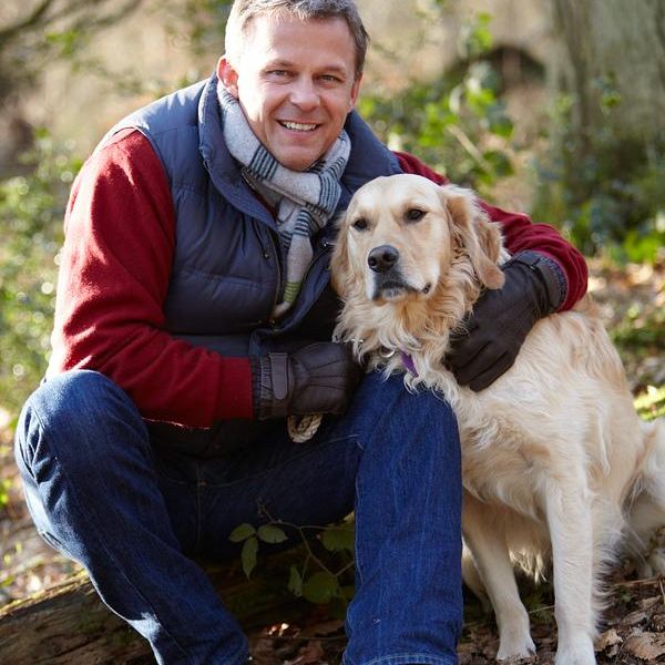Hundesitter mit Labrador im Wald